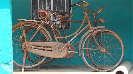 Inde vieux vélos rouillés posés sur un mur bleu