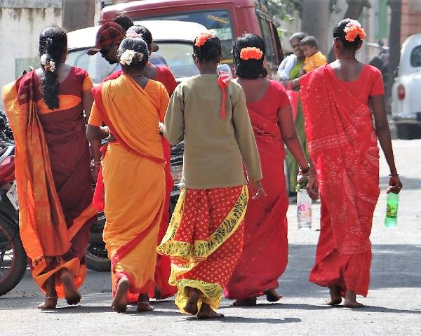 Femmes de dos en saris rouges qui s'éloignent