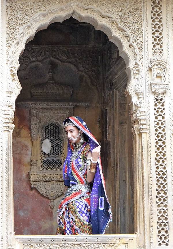 Inde Rajasthan jeune femme en sari posant sous une porte sculptée