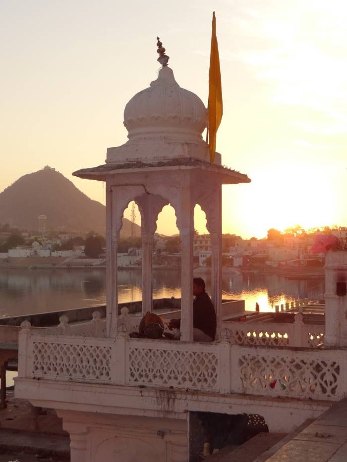 Inde tourelle blanche dans le coucher de soleil, avec un homme assis sous le dôme