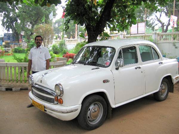 Vieille voiture blanche avec un chauffeur indien