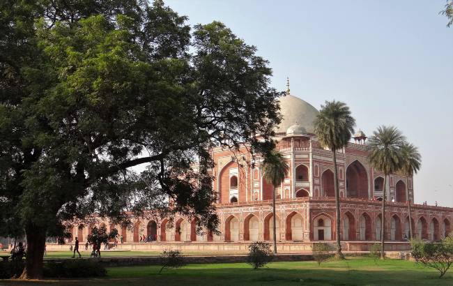 Inde Tombeau en grès rose et marbre blanc cachés derrière des arbres