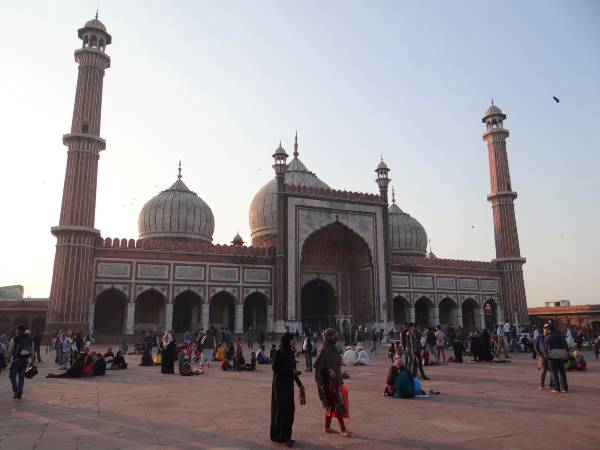 Dômes d'une mosquée entourés de 2 grands minarets avec des silhouettes devant
