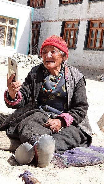 Ladakh Grand-Mère assise par terre avec 1 téléphone portable