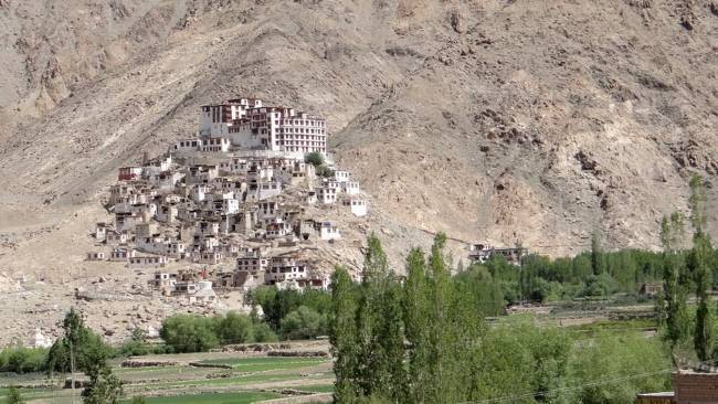 Sur une colline arides, vieilles maisons blanches surmontées d'un monastère