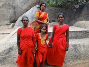 3 femmes indiennes et une petite filles habillées en saris rouges