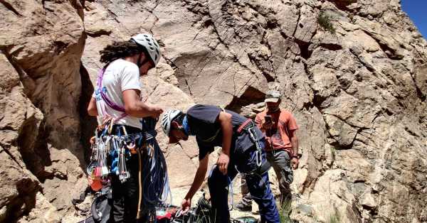 2 hommes avec du matériel d'escalade aux pieds d'une paroi