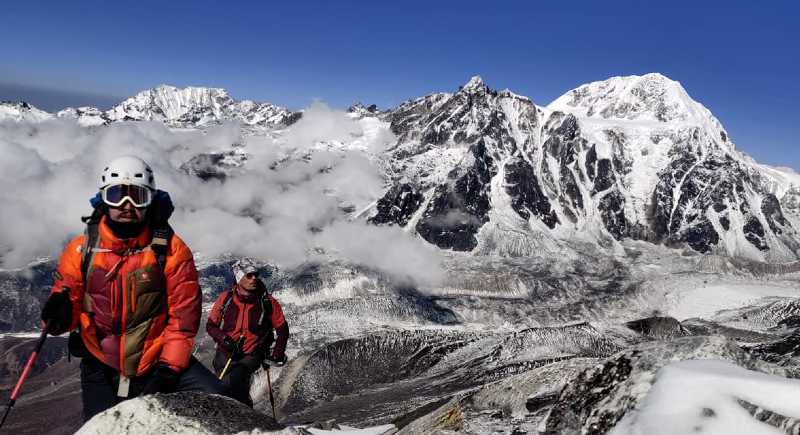 1 alpiniste et des montagnes enneigées au loin