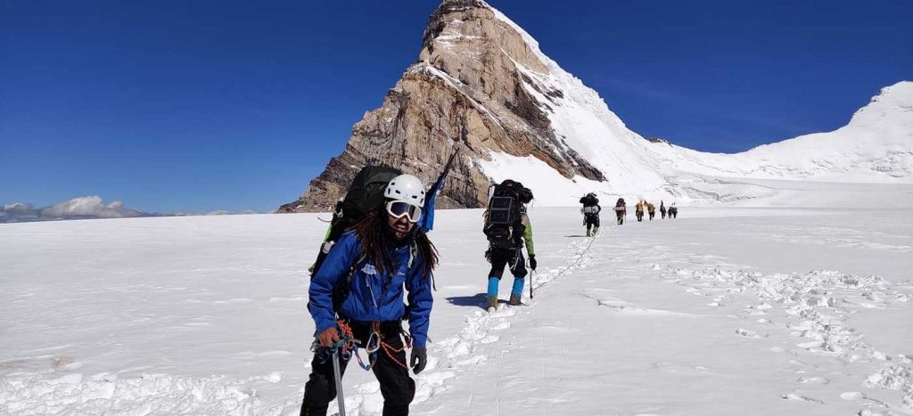 Un alpiniste devant une montagne pointue