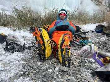 Un homme se repose allongé avec des crampons d'escalade aux pieds