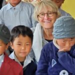 Le visage d'une touriste entouré d'enfants pour la pose