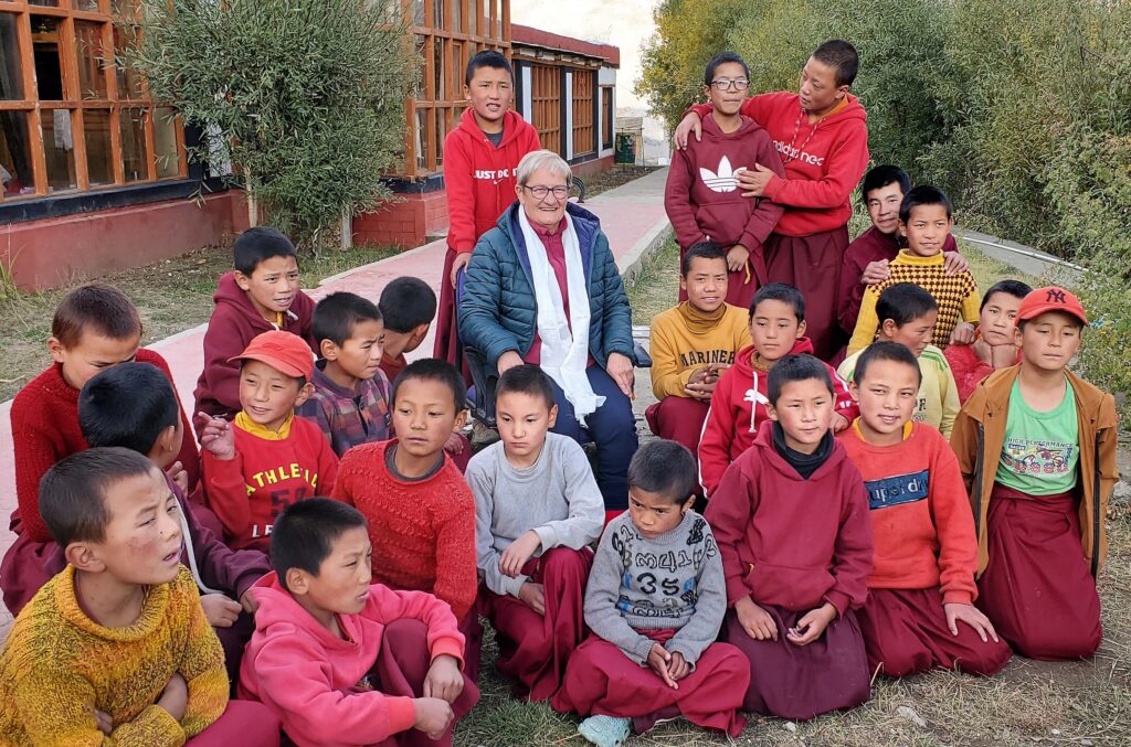 Un groupe d'enfants moines pose pour la photo avec une touriste au centre