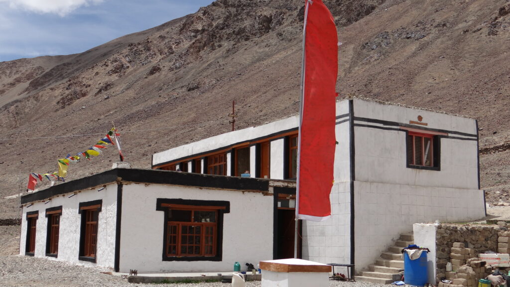Maison du Ladakh avec un drapeau rouge planté devant l'entrée
