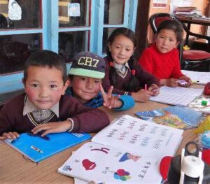 4 enfants alignés devant des livres de classe