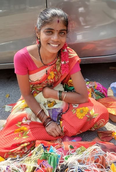 Inde une jeune femme assise par terre sourie au photographe