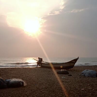 Mamallapuram, barque en contre-jour sur une plage avec le soleil derrière