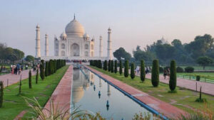 Taj Mahal qui se reflète dans un bassin entouré d'ifs