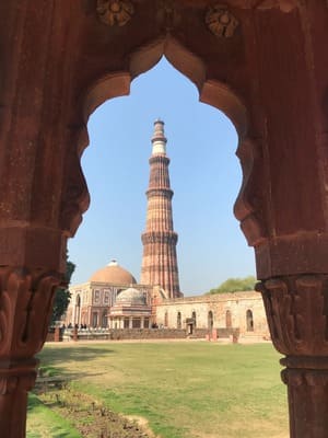 Derrière un porche, on voit un minaret avec des bâtiments autour