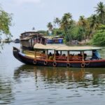 Un bateau qui ressemble à une grosse barque recouverte d'un petit toit transporte des personnes